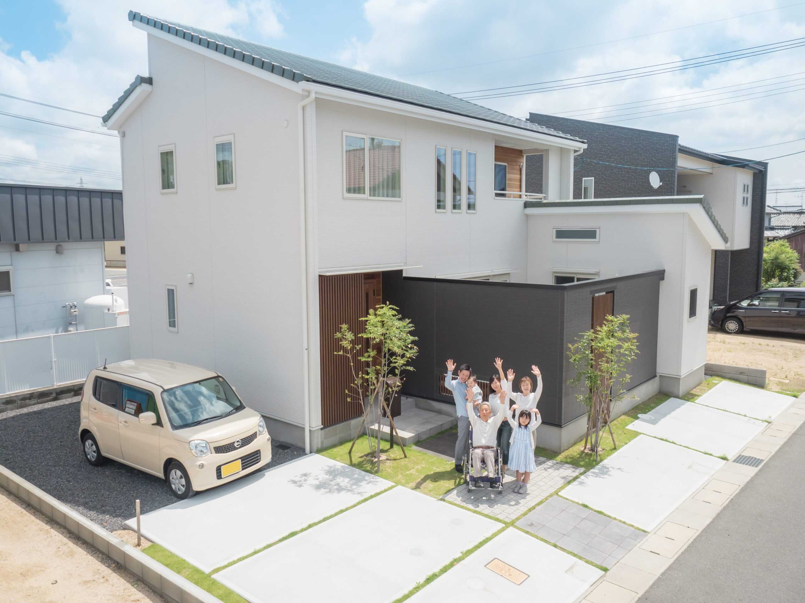 住宅前に立つ家族