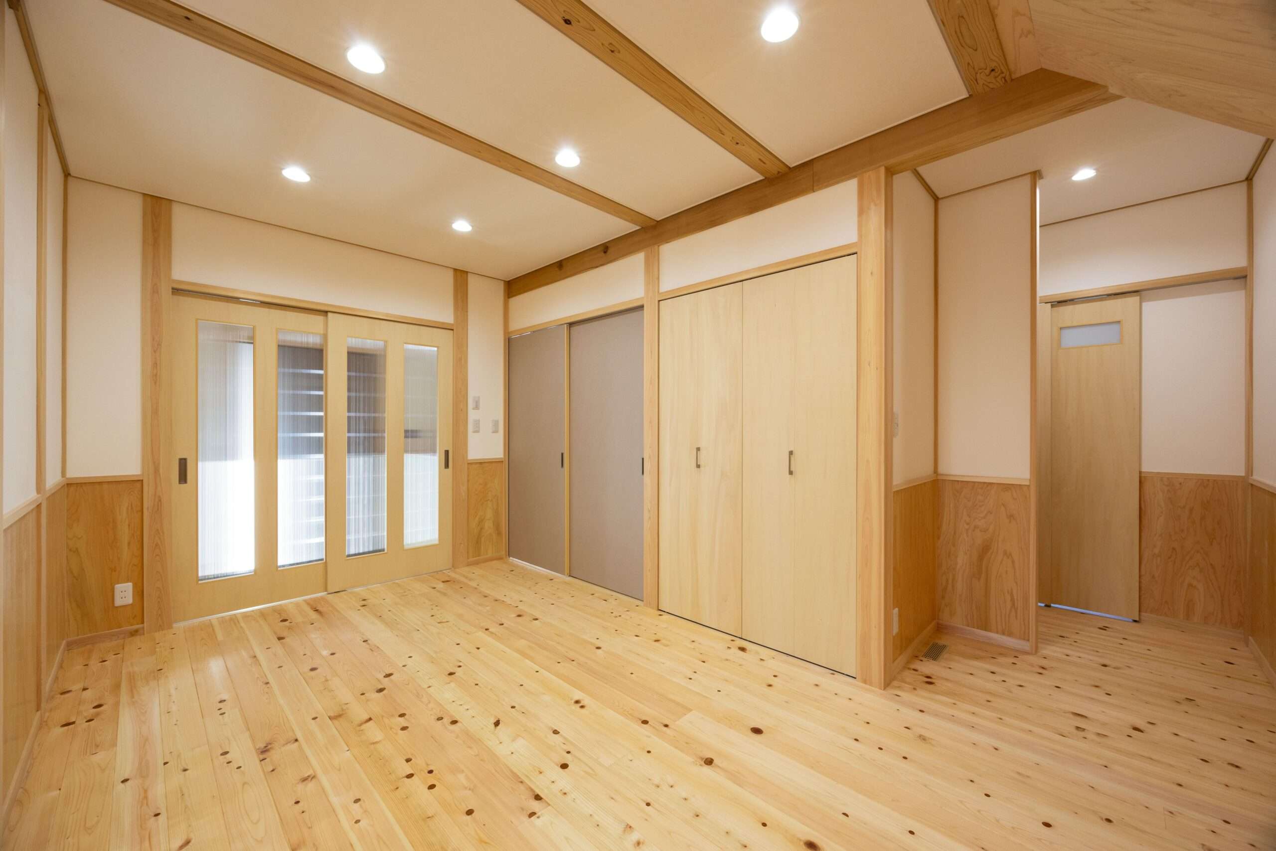 木製引き戸のクローゼットとふすまが並ぶ洋室