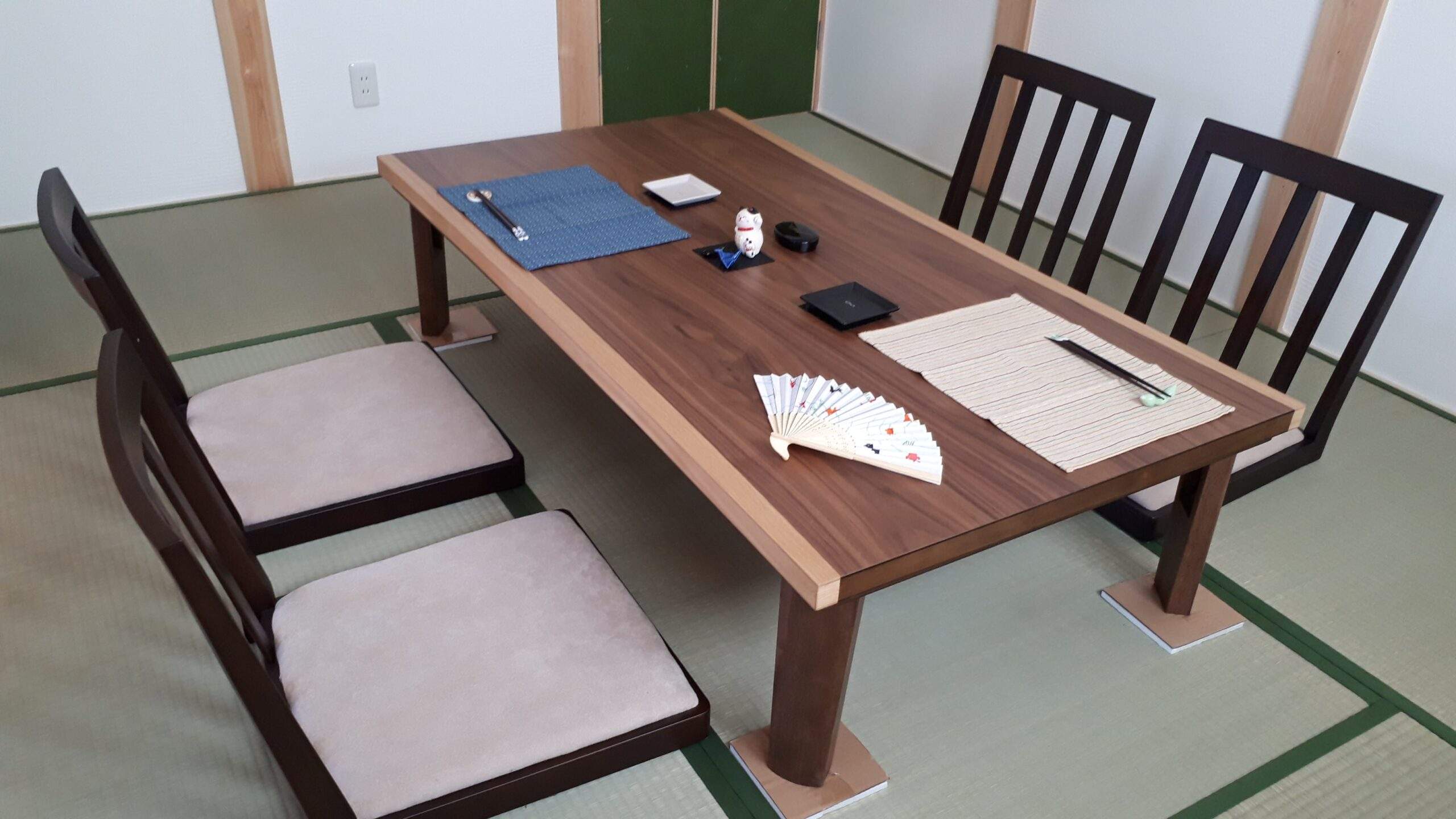 畳敷きの室内に木製座卓と座椅子が並ぶ客間