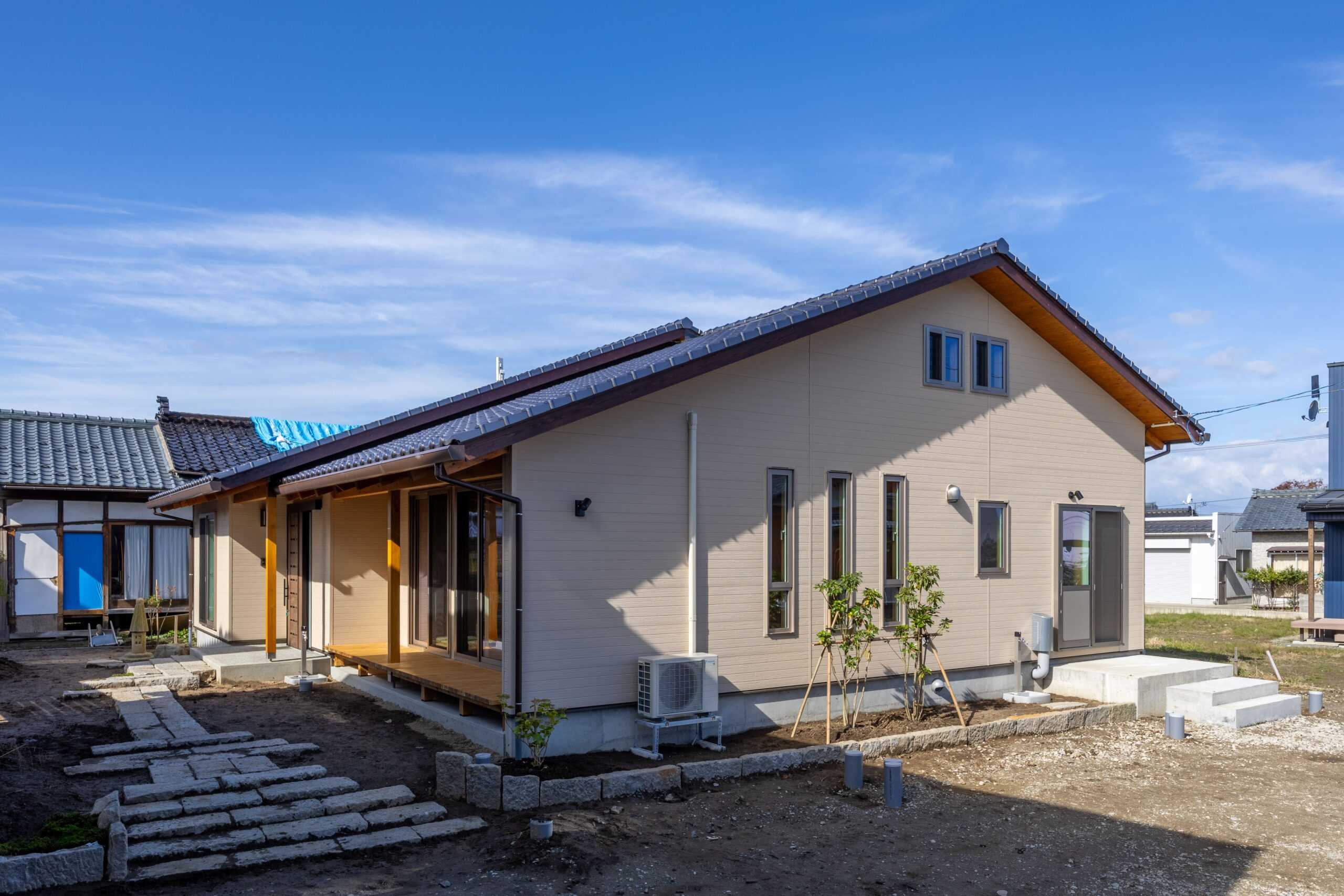 和瓦屋根とベージュサイディングの新築住宅外観