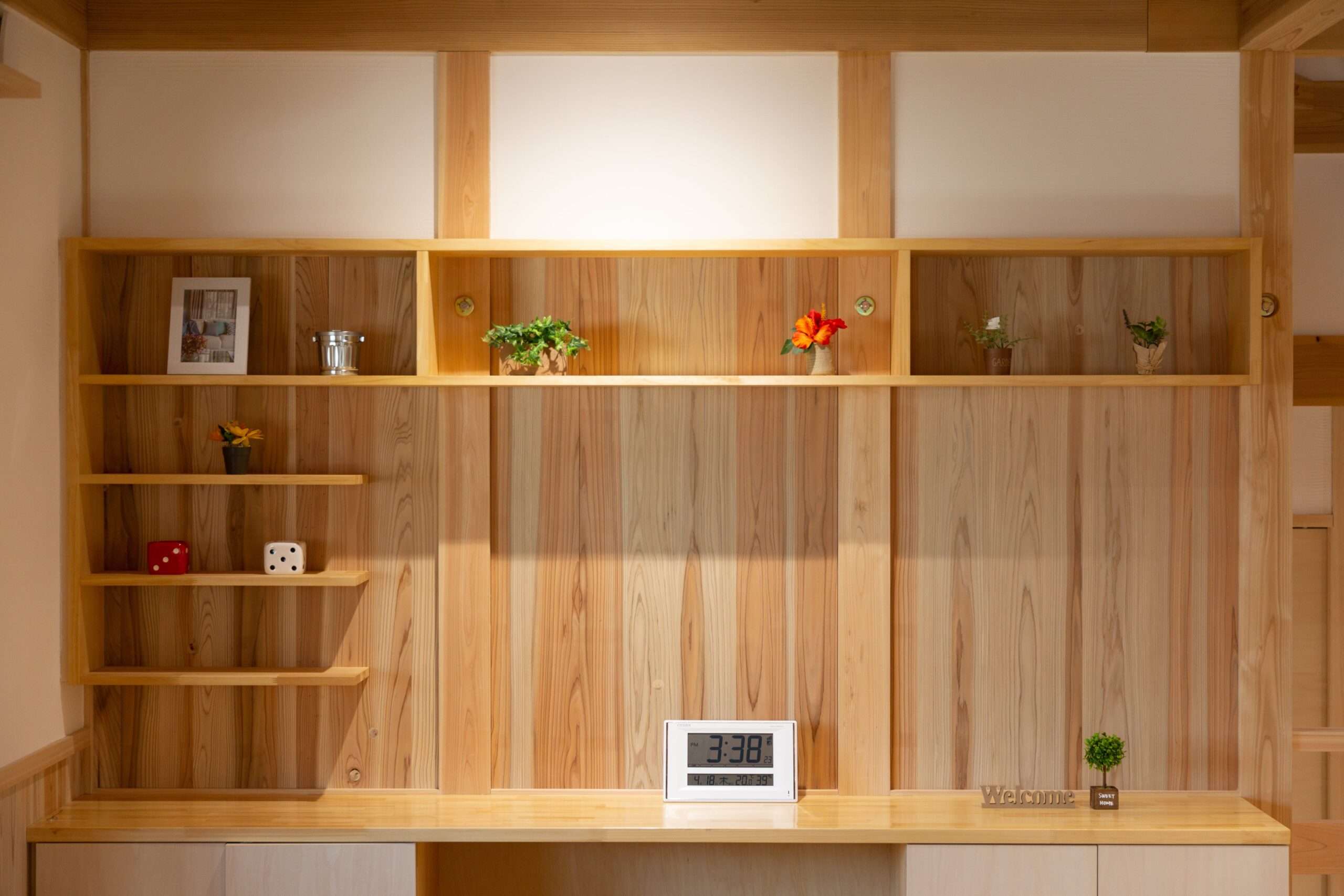 写真や置き時計、観葉植物を飾った木製の造作飾り棚