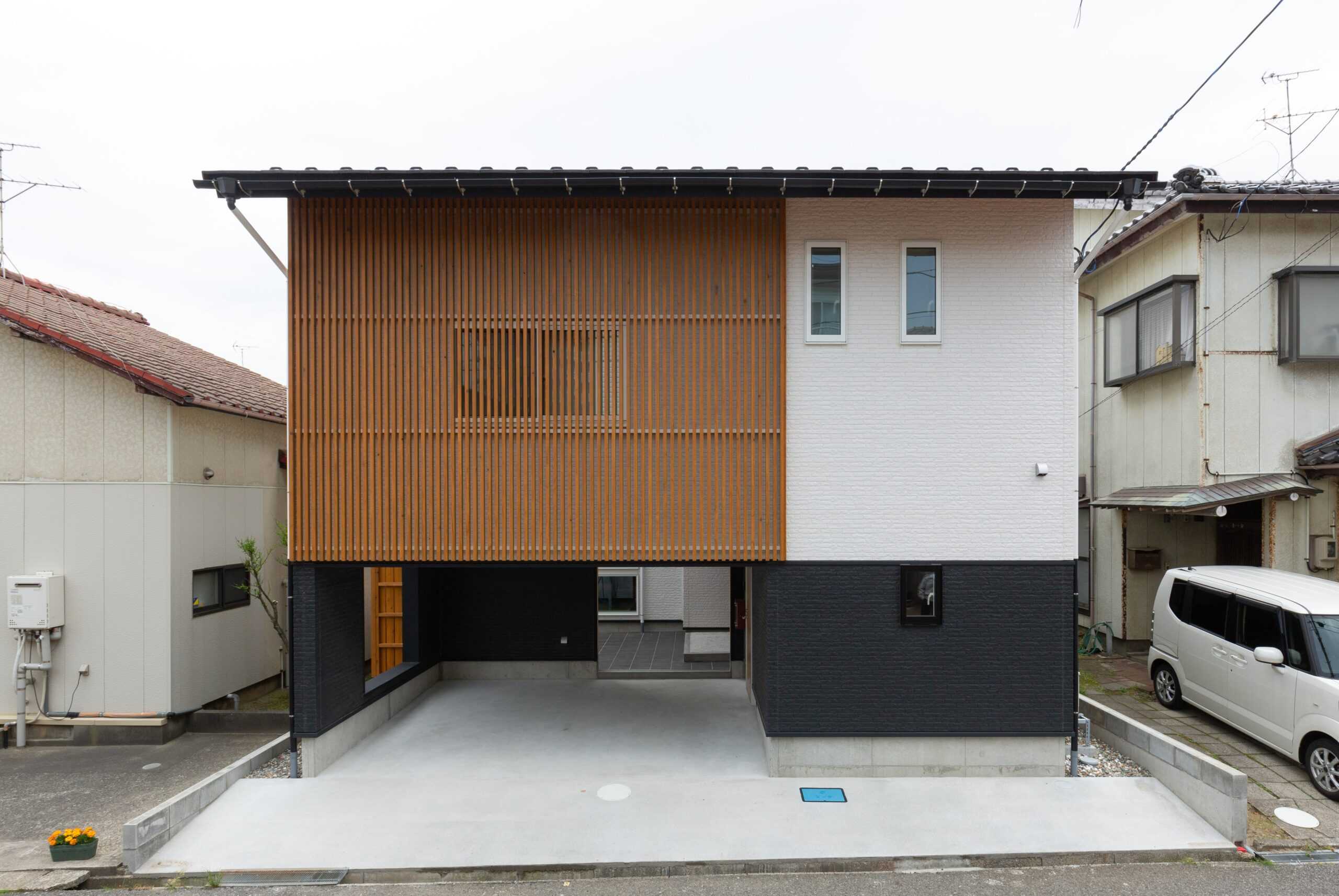 木格子と黒・白を組み合わせた2階建て住宅の外観